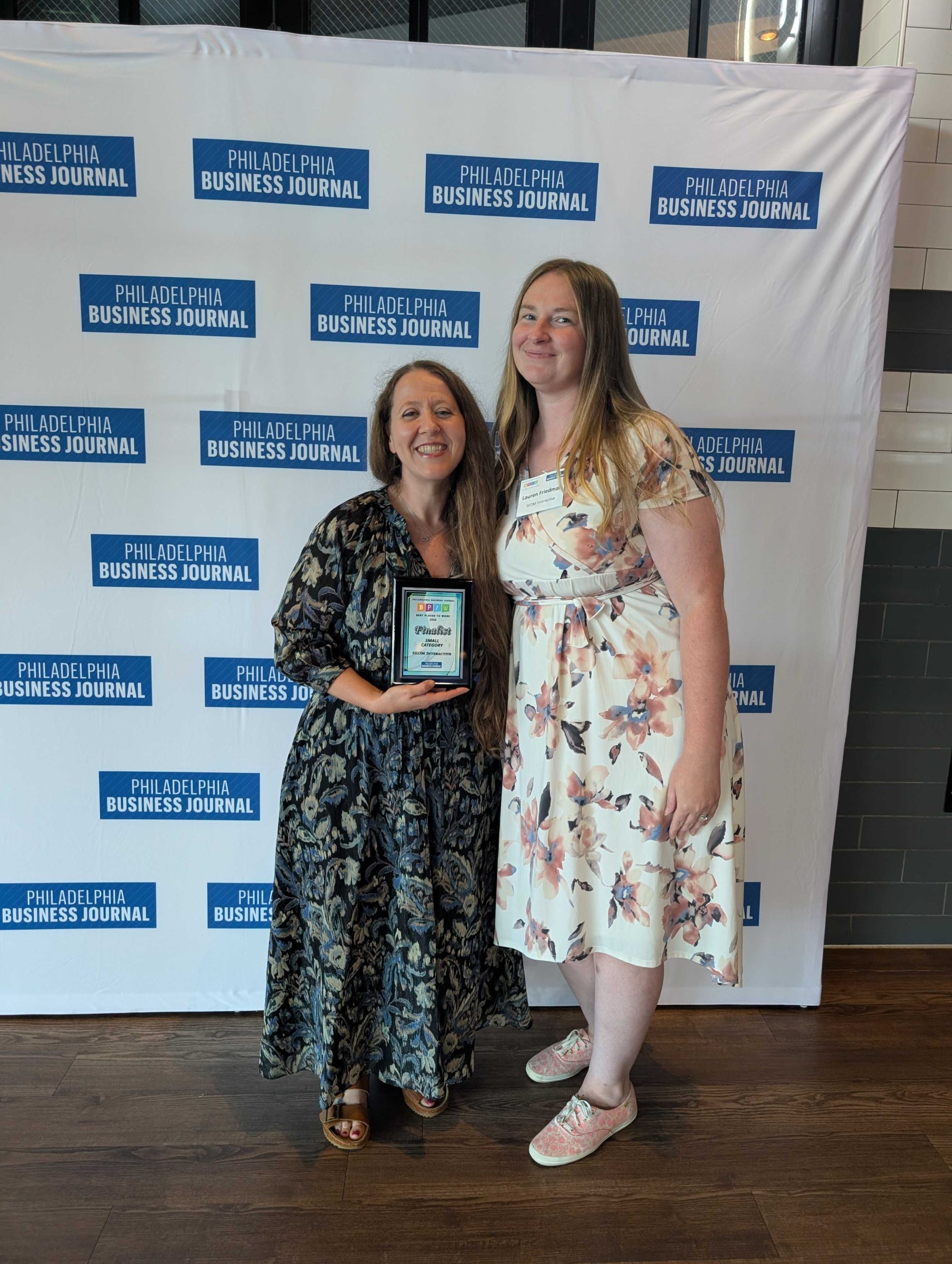 Two SEOM employees posing on the BPTW step and repeat.